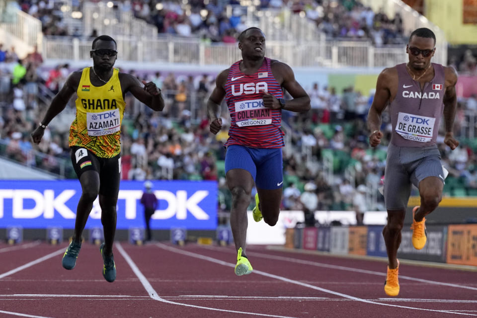 Christian Coleman, center, of the United States, wins a heat in the men's 100-meter run at the World Athletics Championships Friday, July 15, 2022, in Eugene, Ore. (AP Photo/Ashley Landis)