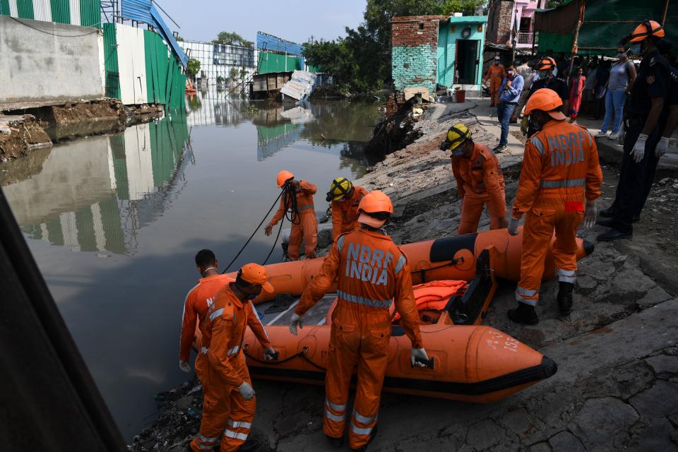 National Disaster Response Force personnel prepare to inspect on a dinghy the area where some shanty houses collapsed into a canal due to heavy rains in New Delhi on July 19, 2020. (Photo by Sajjad HUSSAIN / AFP) (Photo by SAJJAD HUSSAIN/AFP via Getty Images)