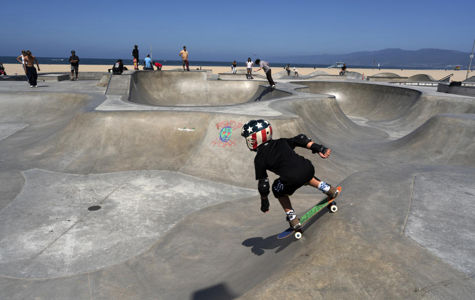 A young skateboarder takes a run at a sparsely crowded Venice beach skateboard park ahead of the 4th of July holiday on Friday, July 3, 2020 in Los Angeles. The Los Angeles County Department of Public Health is ordering L.A. County beaches closed from July 3 through July 6, to prevent dangerous crowding that results in the spread of deadly COVID-19. California's governor is urging people to wear masks and skip Fourth of July family gatherings as the state's coronavirus tally rises. (AP Photo/Richard Vogel)