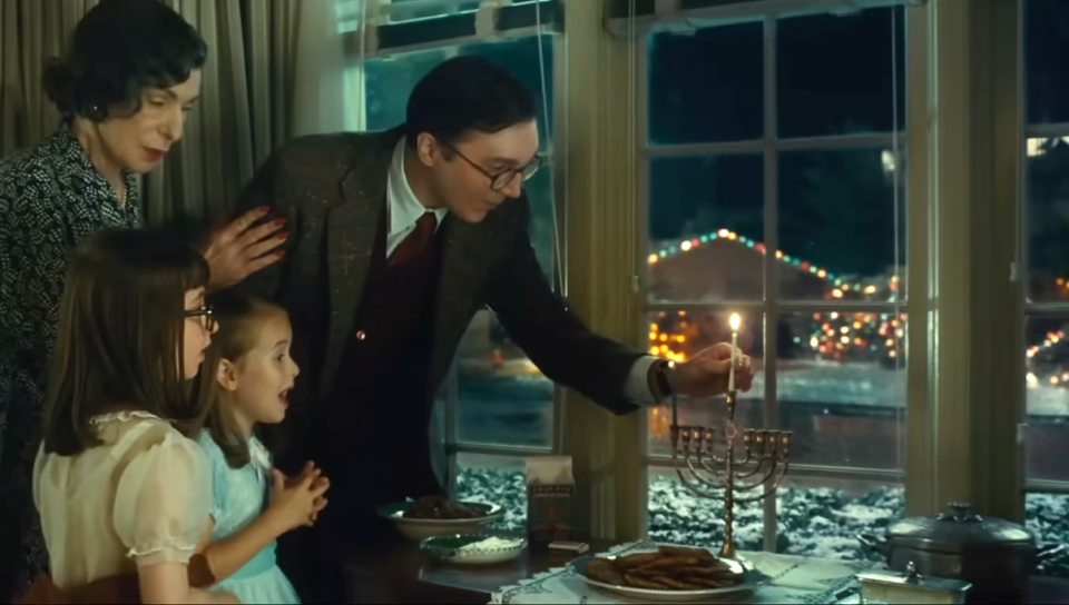 Paul Dano as Burt lighting a menorah with his family