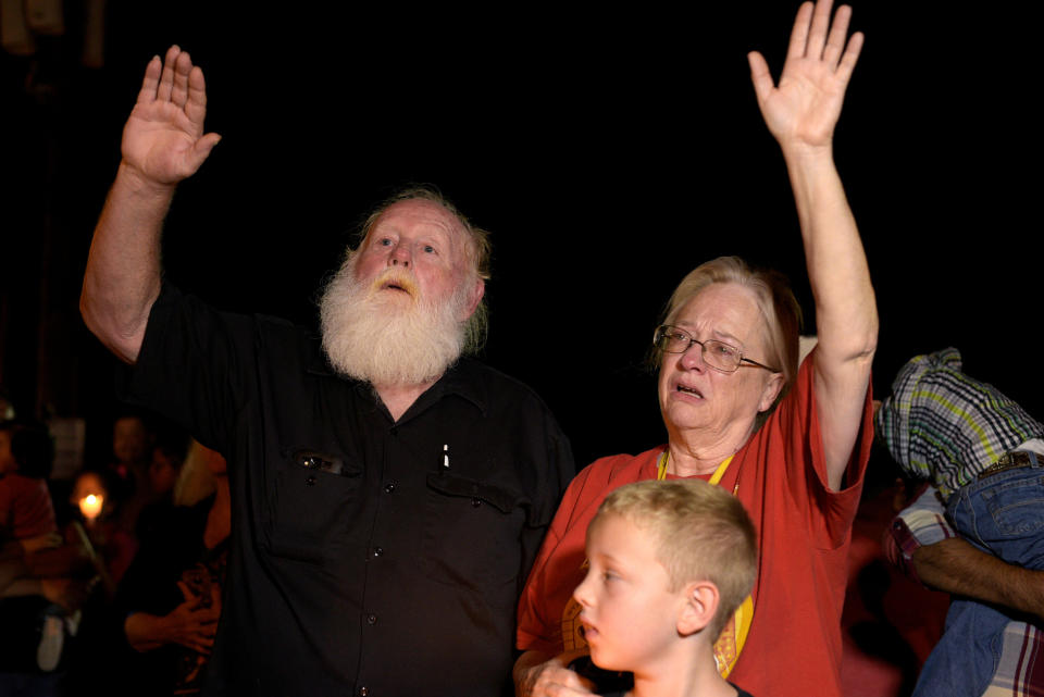 Danny Barker, his wife Tomie and grandson Gage attend a candlelight vigil after a mass shooting at the First Baptist Church.