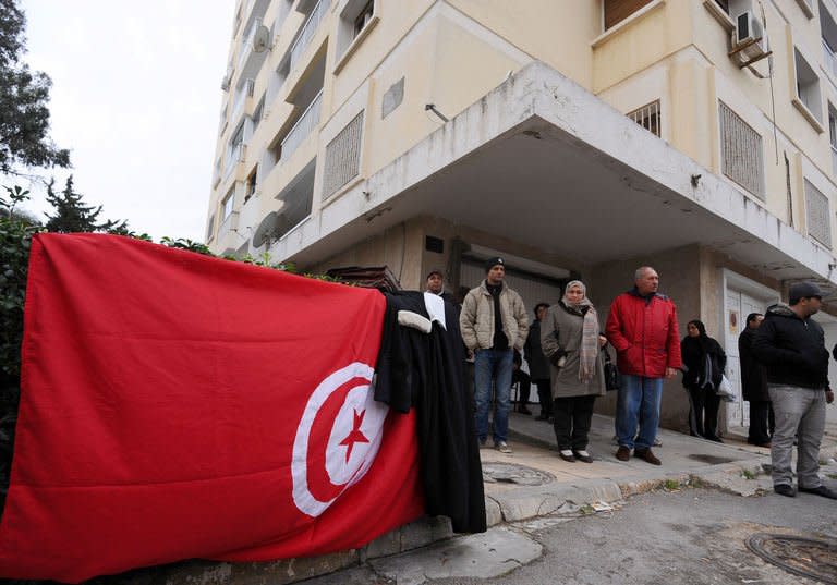 The lawyer's robe and the briefcase of Tunisian opposition leader and outspoken government critic Chokri Belaid are displayed on a national flag in front of the home, where he was shot dead on February 6, 2013 in Tunis