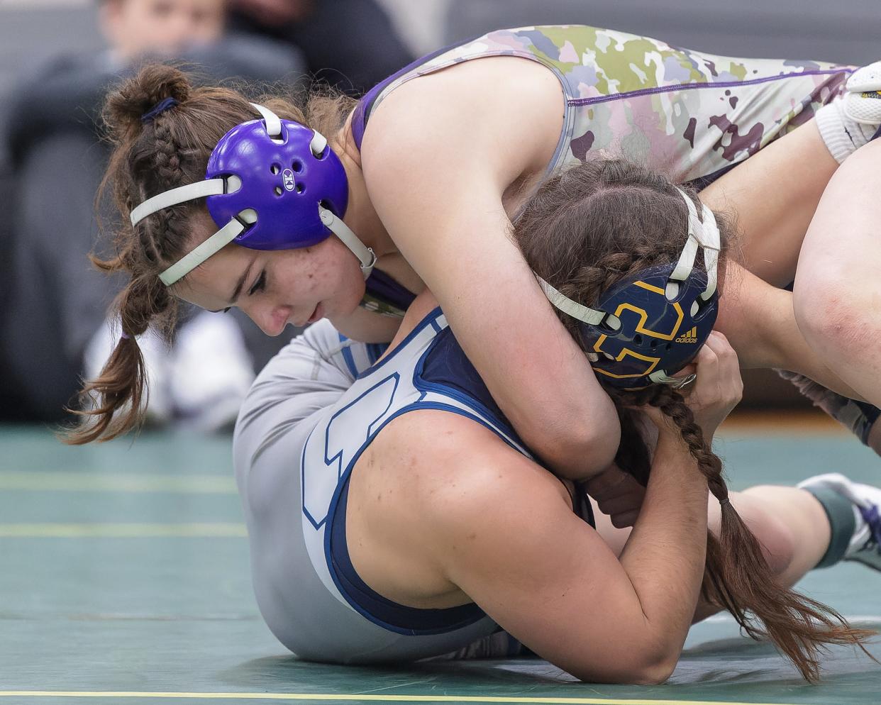 Fowlerville's Maggie Buurma (top) won a regional wrestling title at 135 pounds by pinning previously unbeaten Paisley Denault of Clarkston Sunday, Feb. 18, 2024 in Howell.