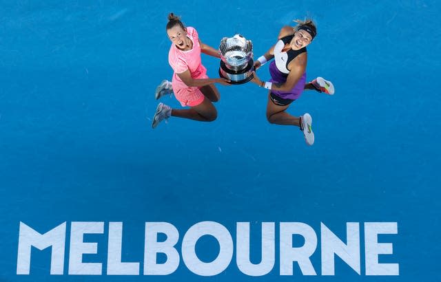 Elise Mertens and Aryna Sabalenka leap into the air after winning the women's doubles title