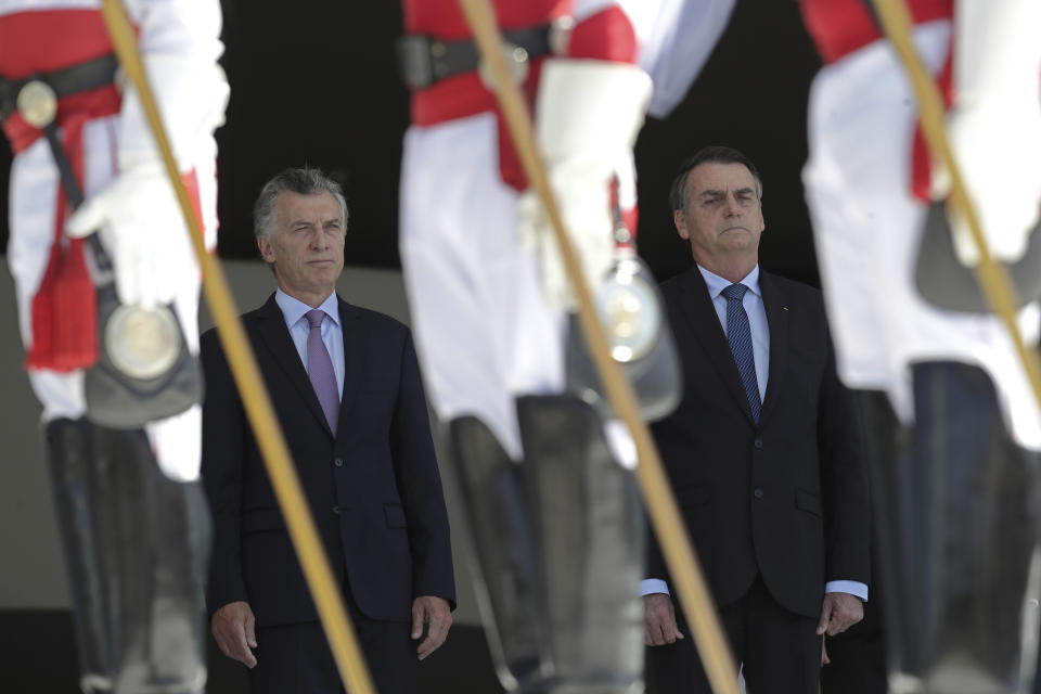 Brazil's President Jair Bolsonaro, right, and the Argentina's President Mauricio Macri, listens to the national anthem of Argentina during a welcome ceremony, at the Planalto presidential palace, in Brasilia, Brazil, Wednesday, Jan. 16, 2019. Macri is on a one-day visit to Brazil. (AP Photo/Eraldo Peres)