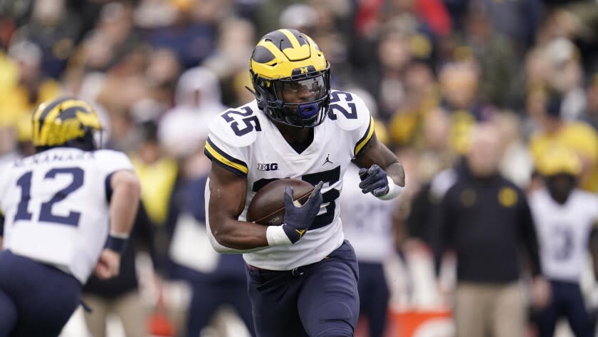 Michigan running back Hassan Haskins runs with the ball against Maryland during the first half of an NCAA college football game between Maryland and Michigan, Saturday, Nov. 20, 2021, in College Park, Md. Michigan won 59-18. (AP Photo/Julio Cortez)