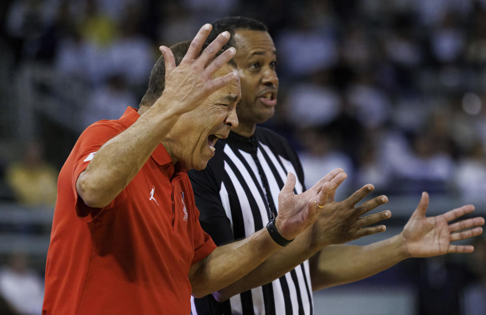 Houston coach Kelvin Sampson, left, talks to official Patrick Evans during the second half of the team's NCAA college basketball game against East Carolina in Greenville, N.C., Saturday, Feb. 25, 2023. (AP Photo/Ben McKeown)
