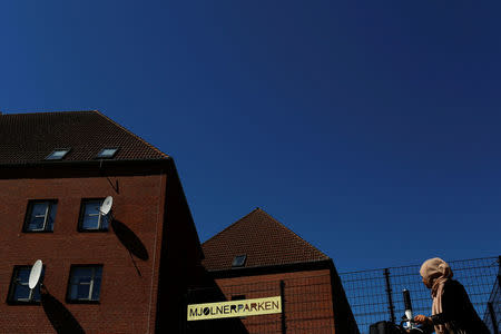 A woman rides by Mjolnerparken, a housing estate that features on the Danish government's "Ghetto List", in Copenhagen, Denmark, May 9, 2018. REUTERS/Andrew Kelly