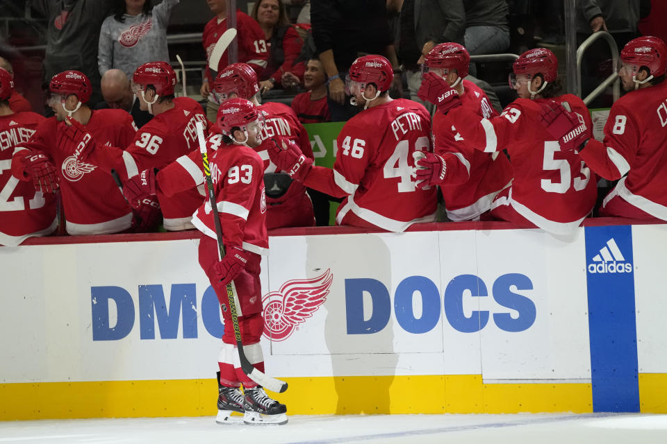 Detroit Red Wings right wing Alex DeBrincat (93) greets teammates after scoring during the first period of an NHL hockey game against the Tampa Bay Lightning, Saturday, Oct. 14, 2023, in Detroit. (AP Photo/Carlos Osorio)