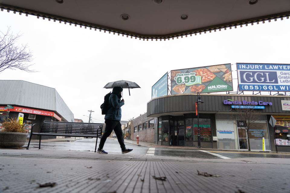 A man uses an umbrella to shield himself from the rain as he walks along Washington Ave in Bergenfield, N.J. on Monday Jan. 23, 2023. 