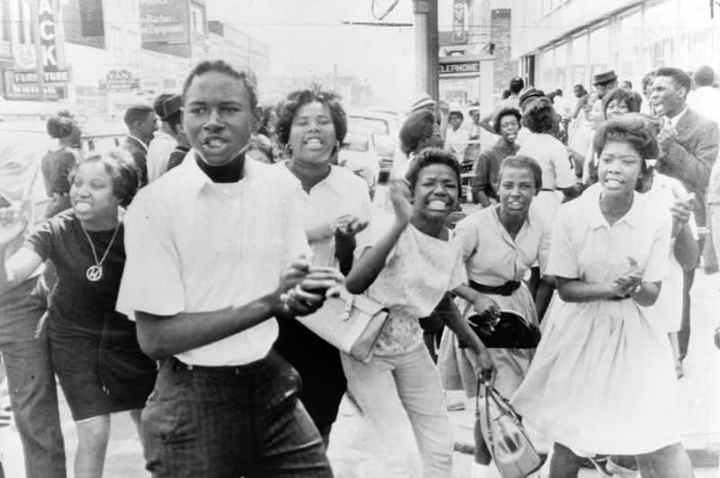 Protesters jeer at policeman standing with photographer in on May 7, 1963, as bands of demonstrators marched until police ordered fire trucks to the scene and hosed them down. On May 11, 1963, bombings in Birmingham, Ala., against non-violent Civil Rights campaigners triggers a crisis which leads to the involvement of federal troops. UPI File Photo