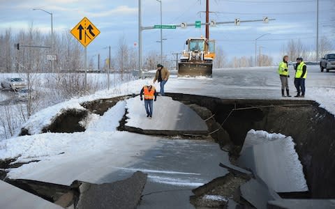 Workers inspect an off-ramp that collapsed during the earthquake - Credit:  Mike Dinneen/AP