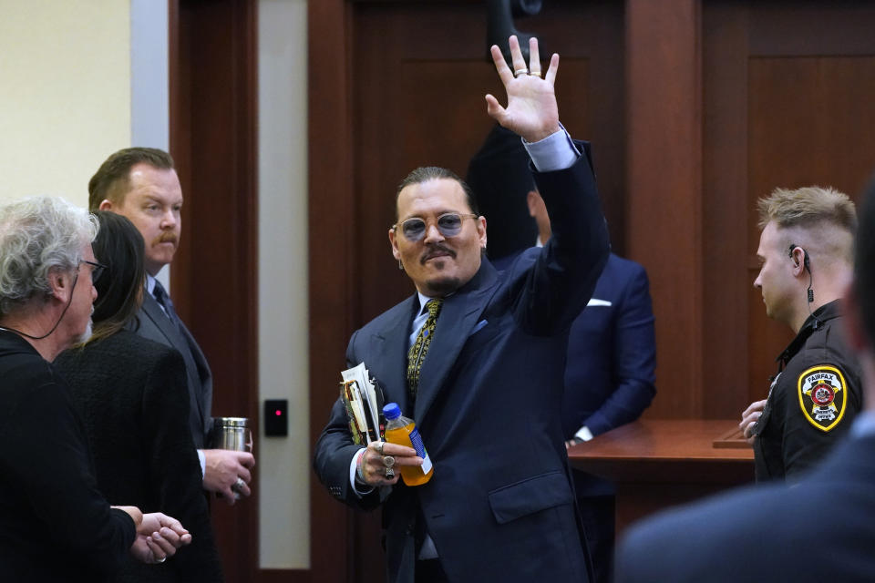 Actor Johnny Depp gestures to the gallery as he leaves for a break in the courtroom at the Fairfax County Circuit Courthouse in Fairfax, Va., Monday, May 23, 2022. Depp sued his ex-wife Amber Heard for libel in Fairfax County Circuit Court after she wrote an op-ed piece in The Washington Post in 2018 referring to herself as a "public figure representing domestic abuse." (AP Photo/Steve Helber, Pool)