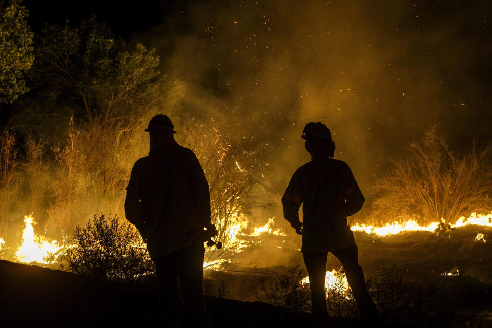 Members of the media watch as a wildfire burns on a hillside Tuesday, Sept. 6, 2022, near Hemet, Calif. (AP Photo/Ringo H.W. Chiu)