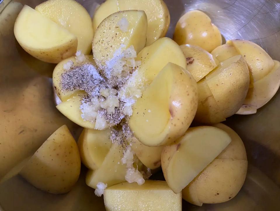 potatoes, oil, and seasoning in a mixing bowl