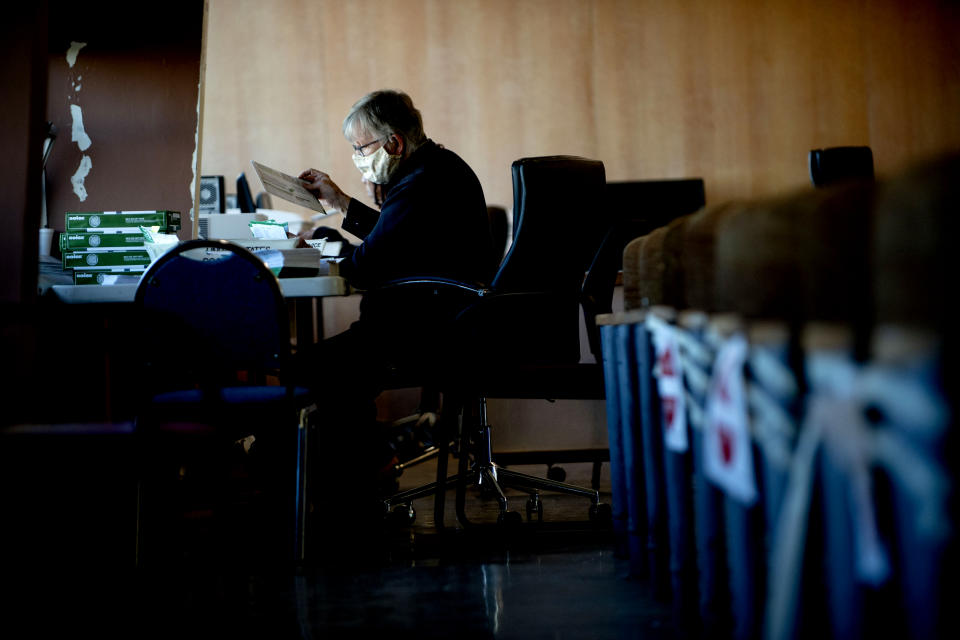 A portion of the absentee ballot counting board works inside the city council chambers at Flint City Hall, Wednesday, Nov. 4, 2020 in Flint, Mich. (Jake May/The Flint Journal via AP)