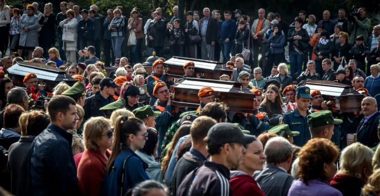 Rescuers carried coffins of victims of the school shooting to the cemetery in the Crimean city of Kerch