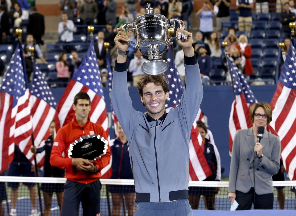 Rafael Nadal of Spain raises his trophy after defeating Novak Djokovic of Serbia (L) in their men's final match at the U.S. Open tennis championships in New York, September 9, 2013.