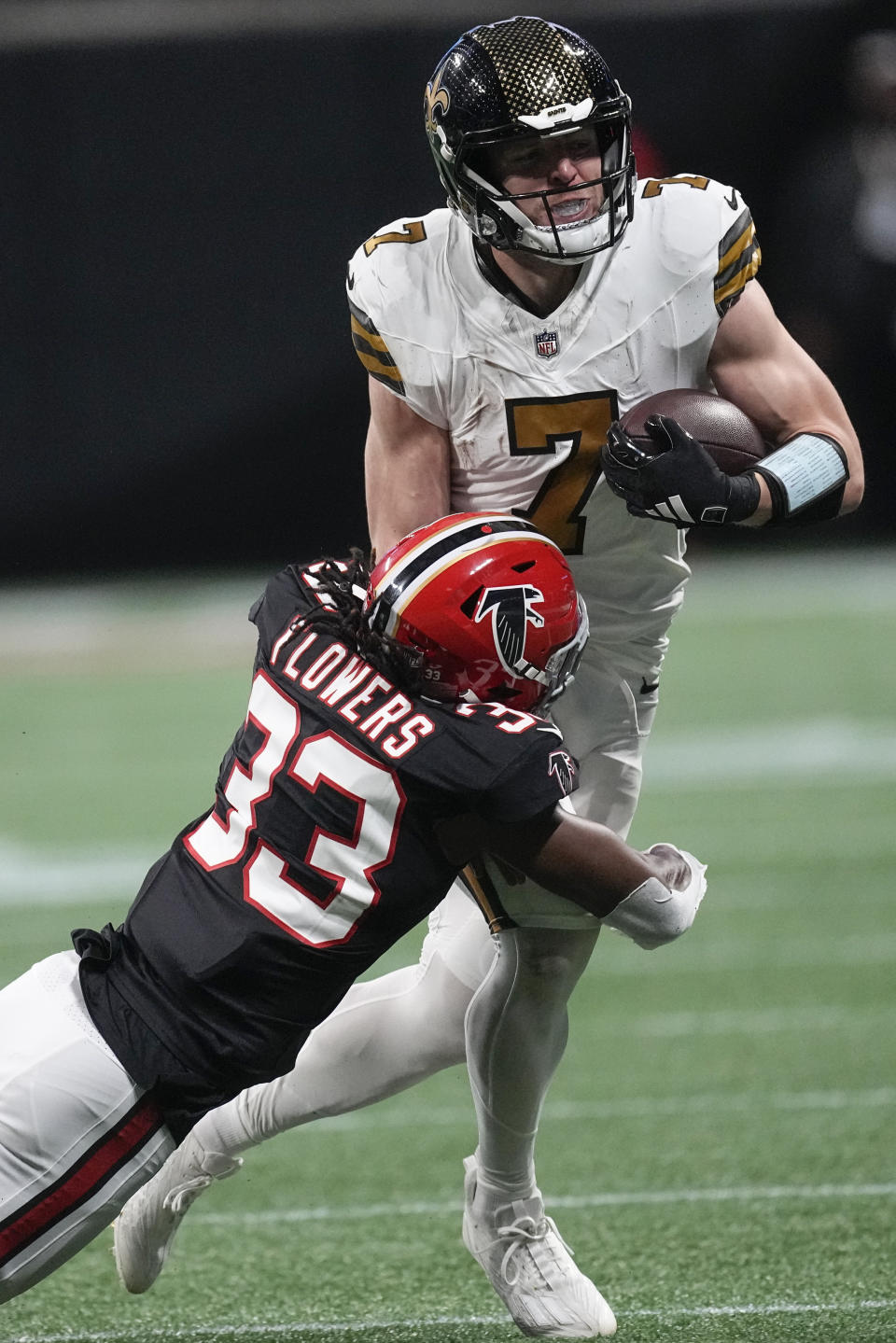 Atlanta Falcons cornerback Tre Flowers (33) hits New Orleans Saints quarterback Taysom Hill (7) during the first half of an NFL football game, Sunday, Nov. 26, 2023, in Atlanta. (AP Photo/John Bazemore)