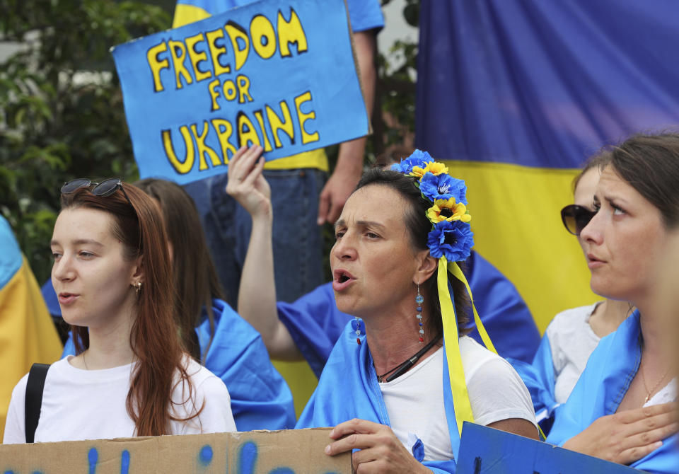 Protestors in support of Ukraine stand with signs and flags during a demonstration outside of an EU summit in Brussels, Thursday, June 23, 2022. European Union leaders are expected to approve Thursday a proposal to grant Ukraine a EU candidate status, a first step on the long toward membership. (AP Photo/Olivier Matthys)