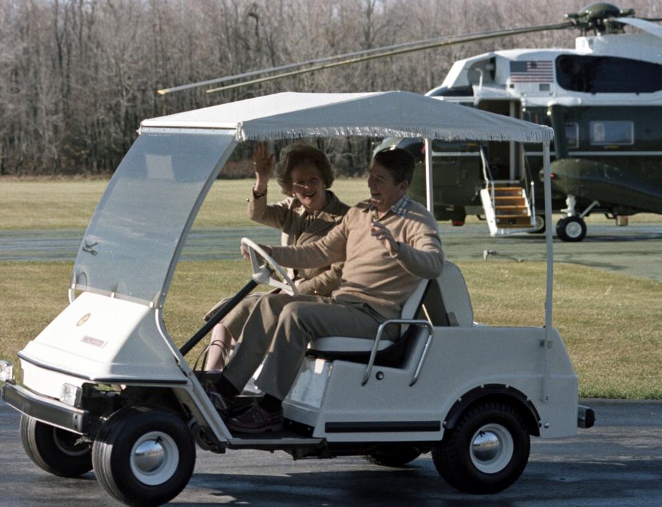 President Ronald Reagan drives British Prime Minister Margaret Thatcher in a golf cart after her arrival for a private visit at Camp David, Md., Dec. 22, 1984.