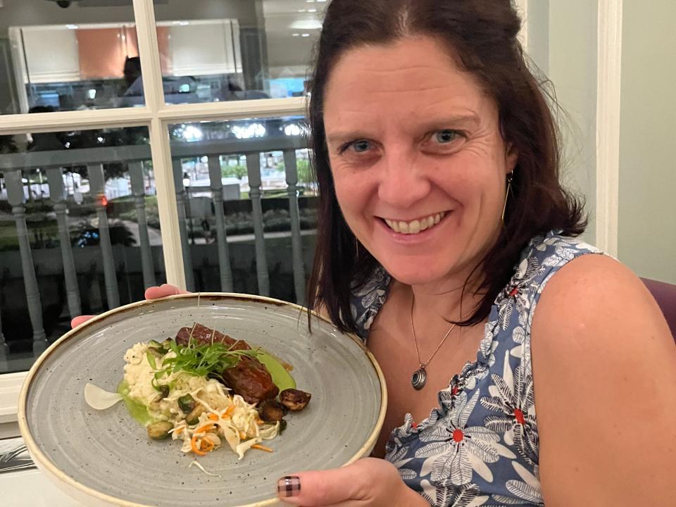 kari holding up her plate of food at citros in disney world