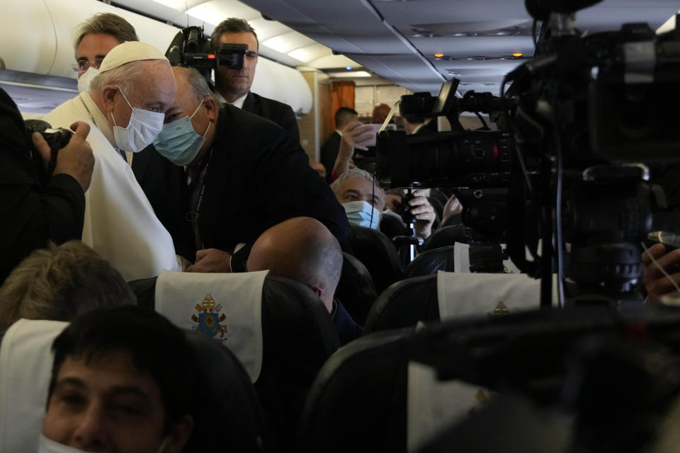 Pope Francis greets the journalists onboard the papal plane on the occasion of his five-day pastoral visit to Cyprus and Greece, Thursday, Dec. 2, 2021.(AP Photo/Alessandra Tarantino, Pool)