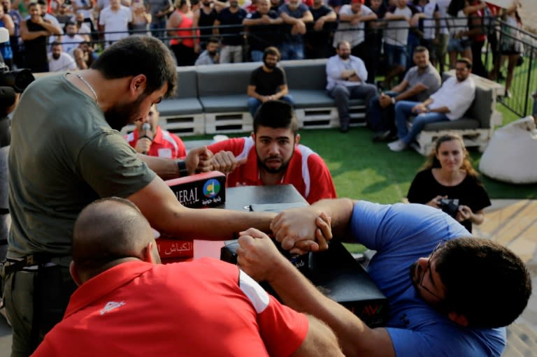 Watched closely by judges, Lebanese men compete in an arm wrestling championship in the coastal city of Jounieh on July 13, 2018