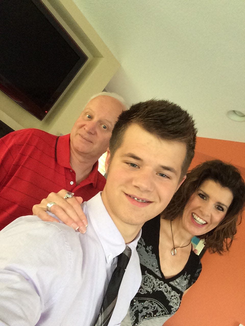 Sergei Neubauer and his parents take a picture in September 2014.
