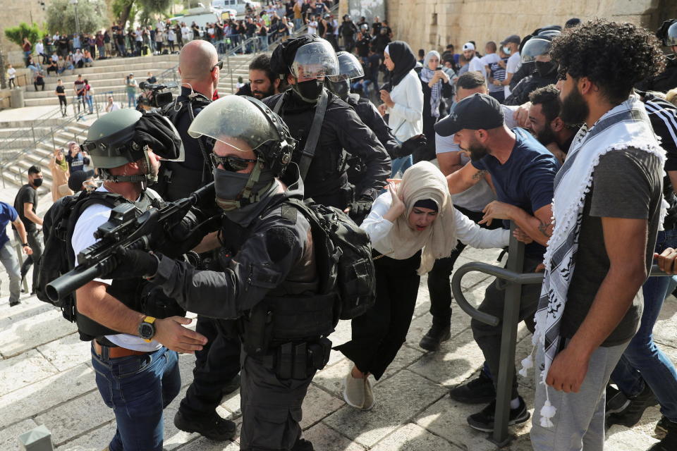 A Palestinian woman reacts during scuffles with Israeli security forces amid Israeli-Palestinian tension as Israel marks Jerusalem Day, near Damascus Gate, outside Jerusalem's Old City on May 10, 2021. / Credit: RONEN ZVULUN/REUTERS