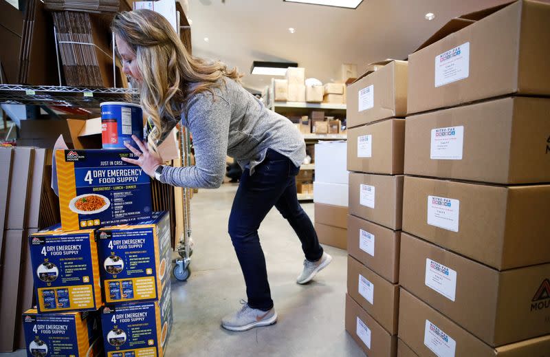 Kristen Curley, owner of Nitro-Pac, stacks boxes of freeze dried food as part of personal protection and survival equipment kits ordered by customers preparing against novel coronavirus, at Nitro-Pak in Midway
