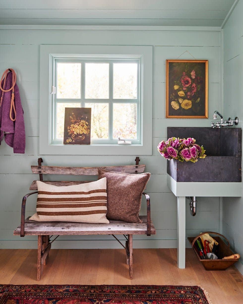 greenish blue mudroom with bench and corner soapstone sink