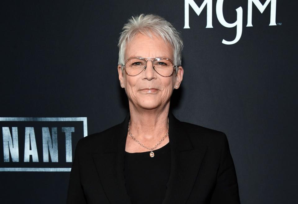 Jamie Lee Curtis stands poised in a sleek suit at an event