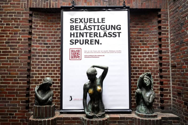 A poster with the inscription "Sexual harassment leaves its mark" hangs behind the bronze sculpture "Youth" by artist Bernhard Hoetger. The women's rights organization Terre de Femmes is setting an example against sexual harassment on well-known female bronze statues in Munich, Berlin and Bremen, using a phenomenon that occurs frequently: time and again, these bronze statues are touched on the breasts by passers-by. Sina Schuldt/dpa