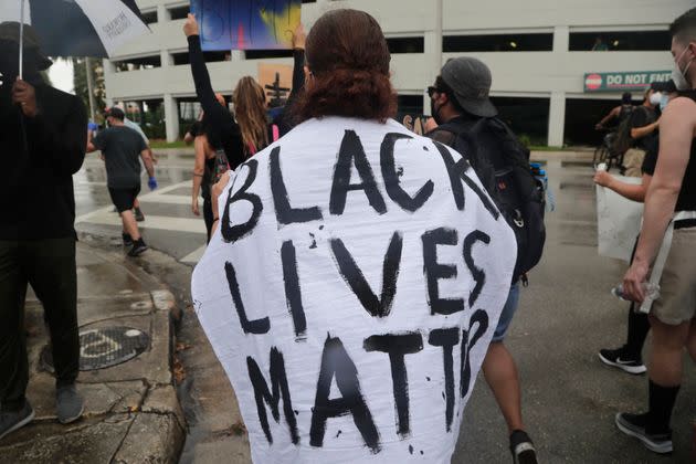 A woman is draped with a cloth reading Black Lives Matter during a protest over the murder of George Floyd on June 2, 2020, in Miami. (Photo: via Associated Press)