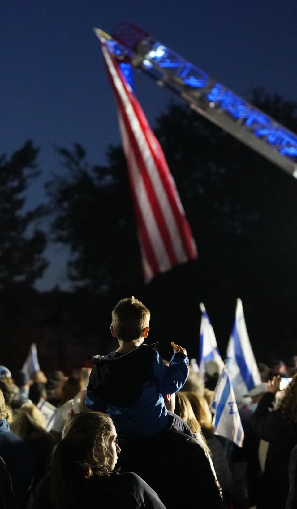 A child sids on a mans shoulder during a candlelight rally to show solidarity and support for the people of Israel at the Rockland County Courthouse in New City hosted by the Jewish Federation & Foundation of Rockland County and the Rockland County Jewish Community on Tuesday, October 10, 2023.