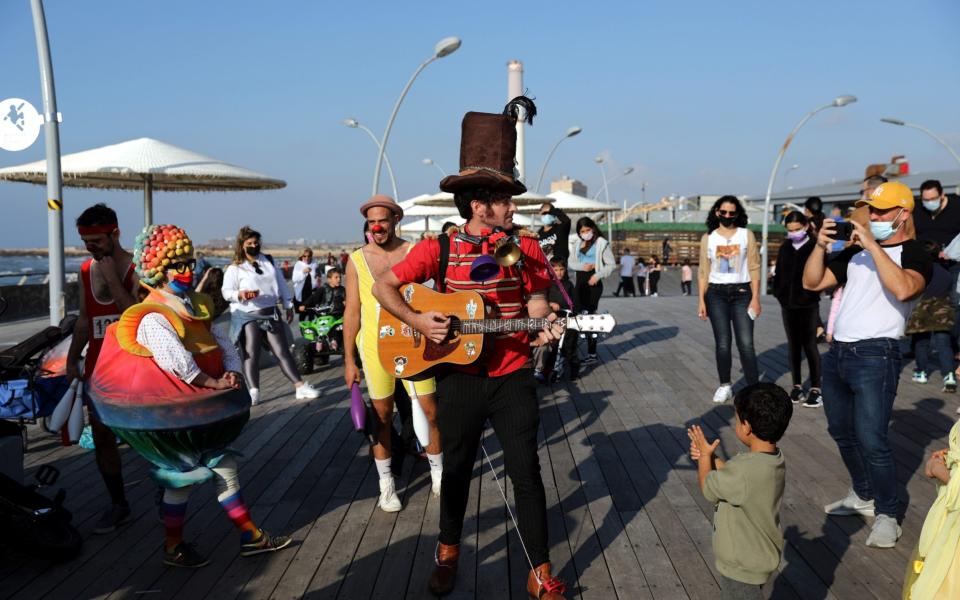 Actors in costumes perform to people during the Purim holiday celebrations in the port of Tel Aviv - Shutterstock