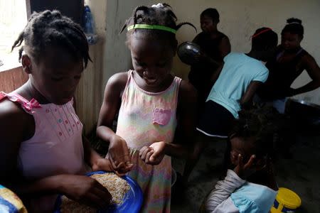 Children eat in a partially destroyed orphanage after Hurricane Matthew passes Jeremie, Haiti, October 11, 2016. REUTERS/Carlos Garcia Rawlins