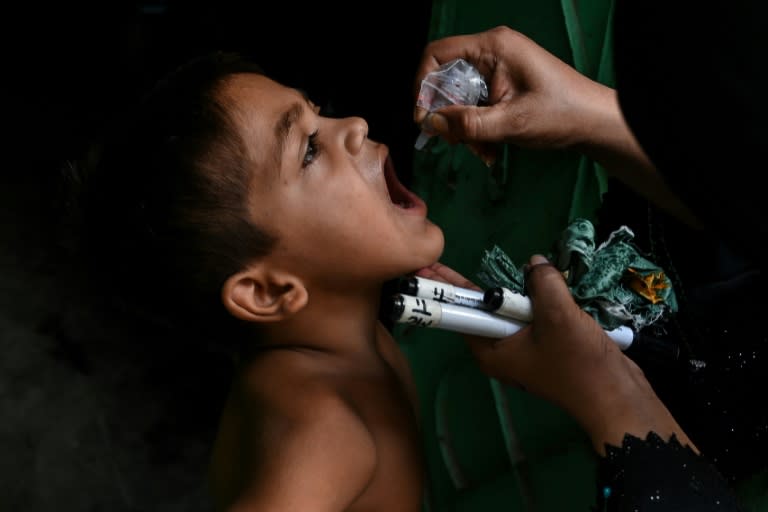 A child receives a dose of polio vaccine during a door-to-door vaccination campaign in Karachi on September 9 (Rizwan TABASSUM)