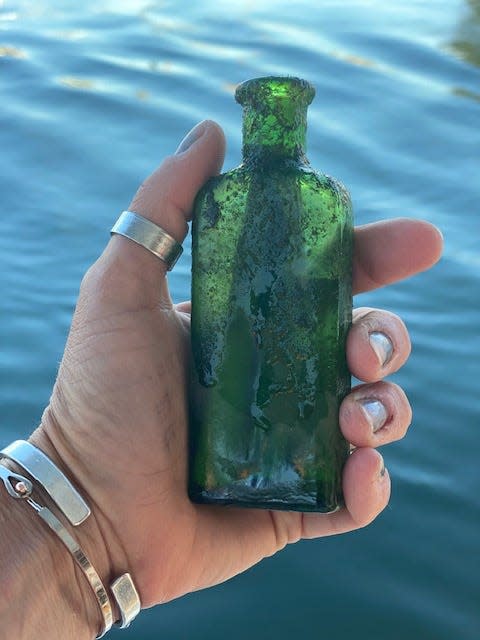 Jennifer Dowker finds green bottle on top of a fish bed when she was cleaning the windows on the bottom of her boat, the Yankee Sunshine.