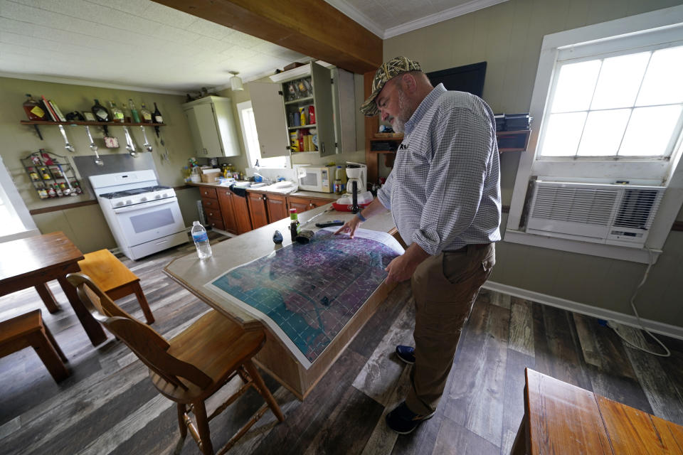 CEO and president Harold Osborn, great-great-grandson of the McIlhenny Co.'s founder, looks at a map of the company's land and surrounding area, inside an old trapper's camp that has been restored and repurposed by the company, on Avery Island, La., where Tabasco brand pepper sauce is made, Tuesday, April 27, 2021. (AP Photo/Gerald Herbert)