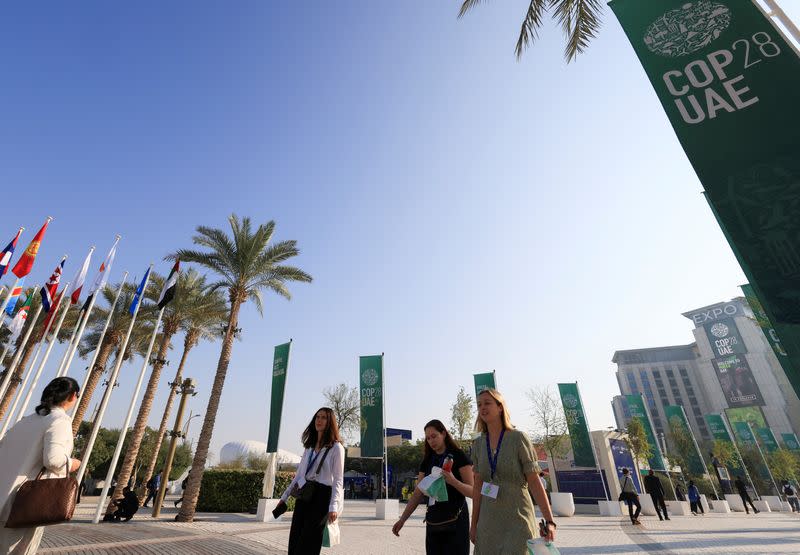 Un grupo de personas camina el domingo por la Expo City de Dubai durante la Conferencia de las Naciones Unidas sobre el Cambio Climático (COP28) en Dubai