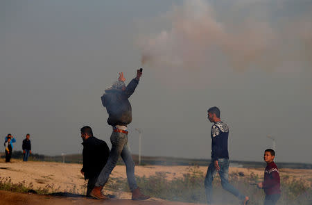 A Palestinian demonstrator holds a tear gas canister fired by Israeli troops during a protest at the Israeli-Gaza border fence, east of Gaza City March 29, 2019. REUTERS/Mohammed Salem
