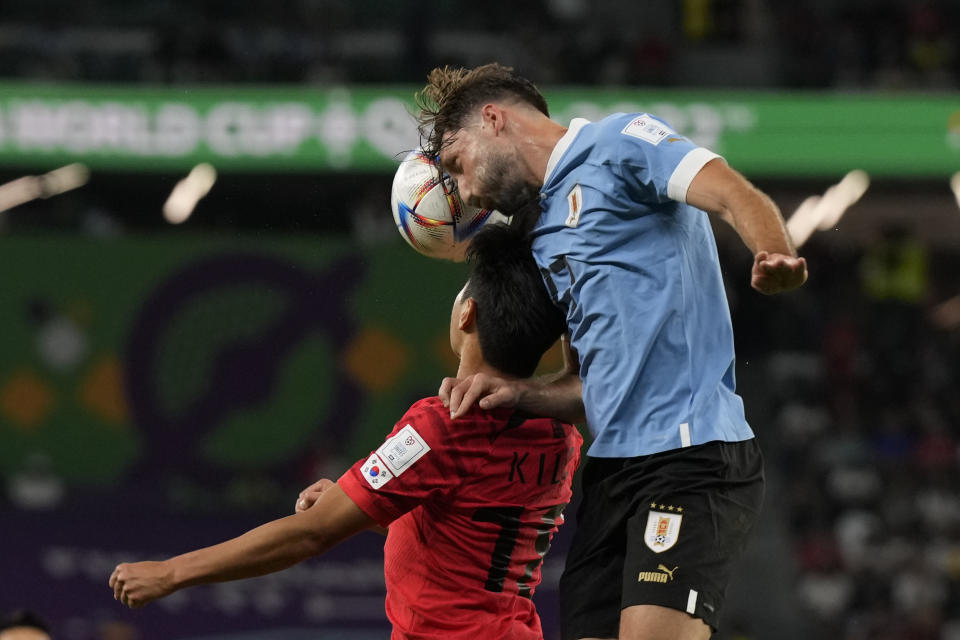 Uruguay's Matias Vina, right, and South Korea's Lee Kang-in go for a header during the World Cup group H soccer match between Uruguay and South Korea, at the Education City Stadium in Al Rayyan , Qatar, Thursday, Nov. 24, 2022. (AP Photo/Alessandra Tarantino)