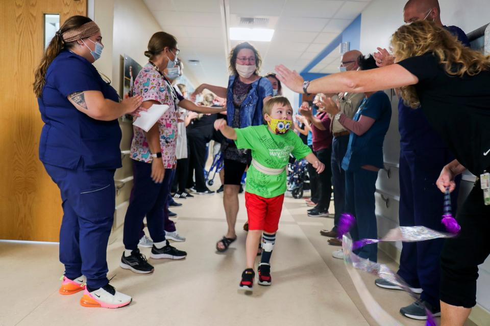 The staff claps as Waylon Wehrle, 7, heads home from the Mary Free Bed Rehabilitation Hospital in Grand Rapids, Michigan. The boy had COVID-19 in the spring and developed life-threatening complications, and spent months in the hospital and rehab.