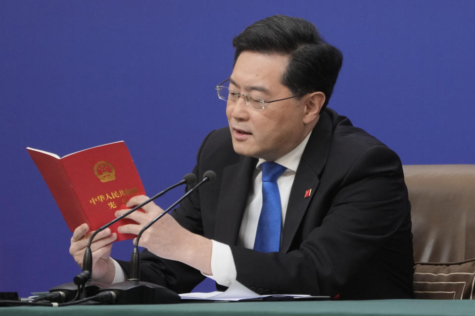 Chinese Foreign Minister Qin Gang reads from the Chinese constitution when answering a question about Taiwan during a press conference held on the sidelines of the annual meeting of China's National People's Congress (NPC) in Beijing, Tuesday, March 7, 2023. (AP Photo/Mark Schiefelbein)