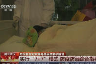 In this Thursday, Jan. 23, 2020, image from China's CCTV video, a patient is carried on a stretcher to an ambulance in Wuhan, China. China is swiftly building a hospital dedicated to treating patients infected with a new virus that sickened hundreds and prompted unprecedented lockdowns of cities home to millions of people during the country's most important holiday. (CCTV via AP)