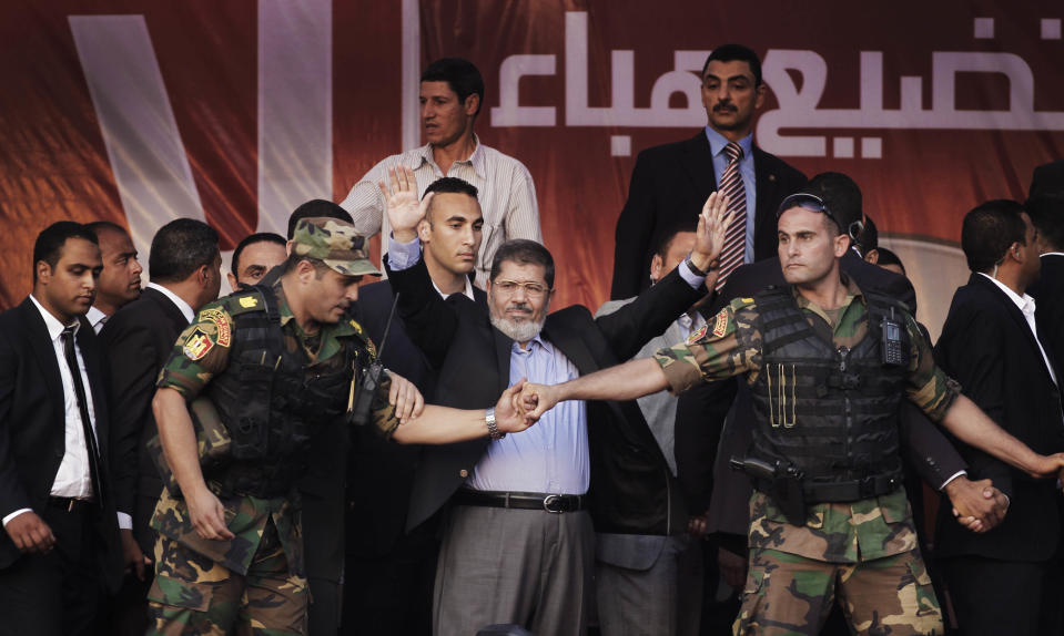 FILE - In this Friday, June 29, 2012 file photo, Egypt's new President-elect Mohammed Morsi waves to supporters after giving a speech at Tahrir Square in Cairo, Egypt. Egyptian officials say security authorities leaked a recording of a private conversation between ousted President Mohammed Morsi and his lawyer on the sidelines of his trial, in which Morsi says protests by his supporters and the crackdown on them are "useless." (AP Photo/Khalil Hamra, File)