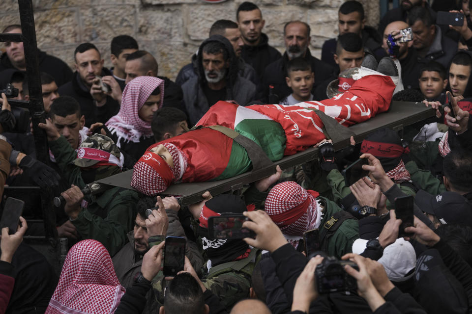 Palestinian mourners carry the body of Adam Ayyad during his funeral, in the West Bank city of Bethlehem, Tuesday, Jan. 3, 2023. The Palestinian Health Ministry said Adam Ayyad, 15, died of a bullet wound to the chest. The Israeli military said Border Police officers came under attack in the Dheisha refugee camp next to Bethlehem. It said troops shot at people throwing firebombs and confirmed that a person was shot. (AP Photo/Mahmoud Illean)