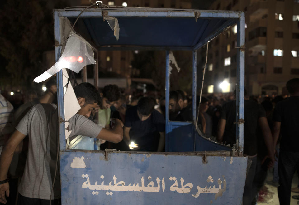 Palestinians check a damaged police booth following an explosion targeted a Hamas police checkpoint in Gaza City, Tuesday, Aug. 27, 2019. (AP Photo/Khalil Hamra)